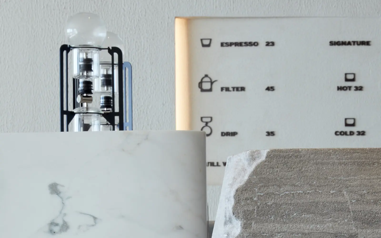 The Orijins menu board and cold brew tower behind the bar