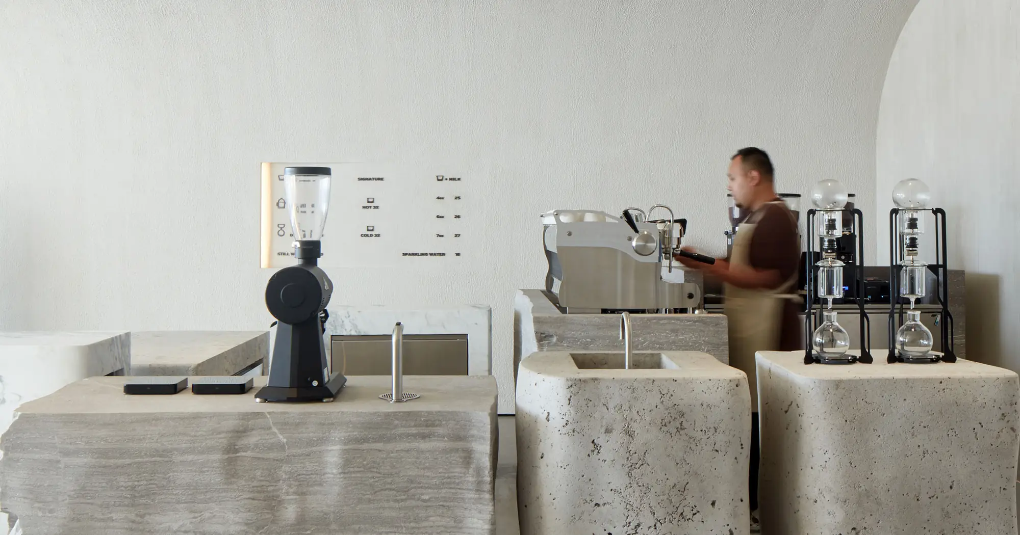 Inside Orijins: travertine counters and warm light in Gate Village 8, DIFC